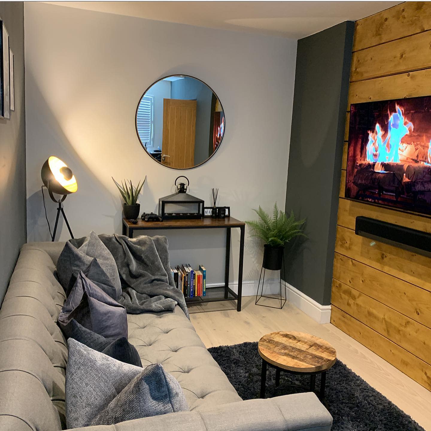 small living room shiplap wall mounted tv gray sofa wall mirror 